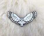 Snowy owl pin on lambskin background