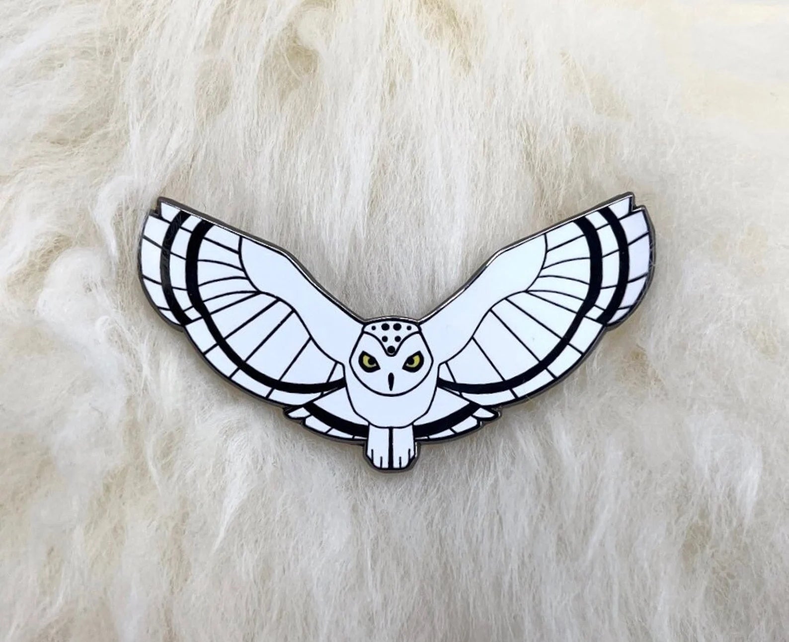 Snowy owl pin on lambskin background